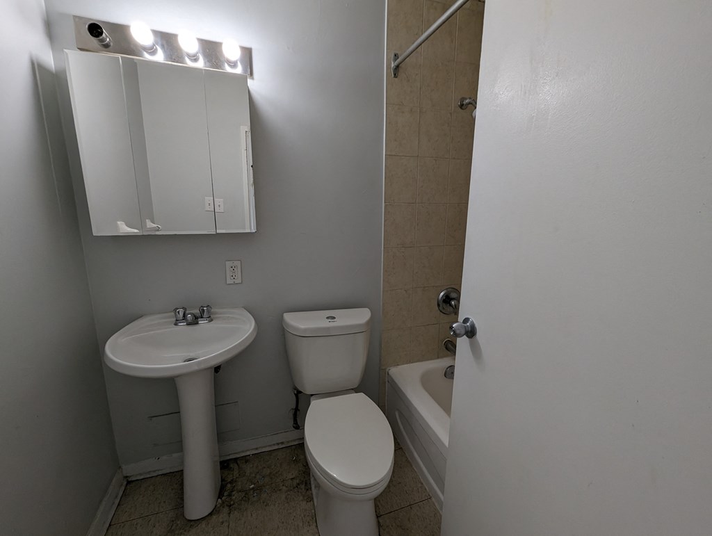 an empty bathroom with a sink toilet and tub