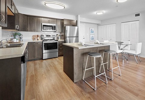 a kitchen with a large island with bar stools