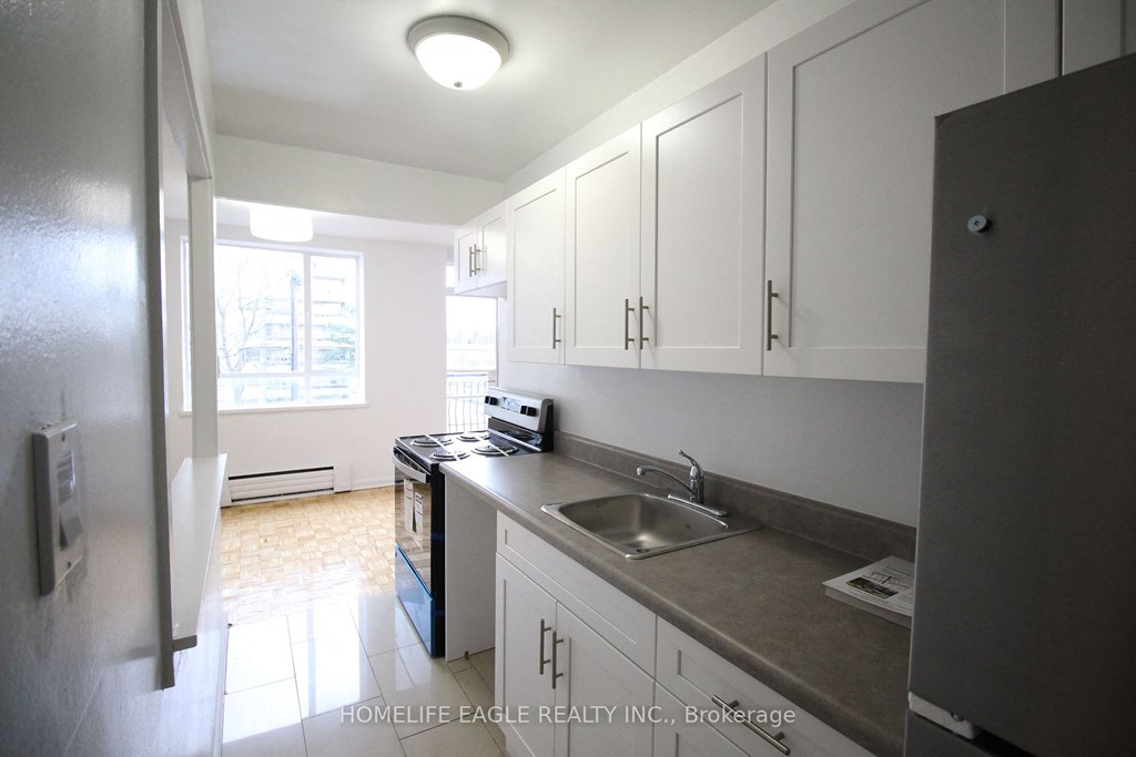 an empty kitchen with white cabinets and a sink