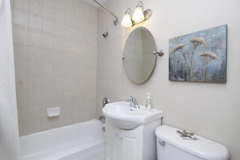 a white bathroom with a sink and a tub