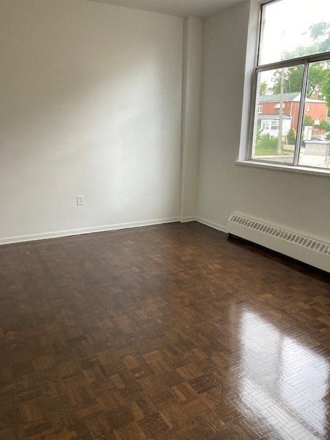 an empty room with a window and a radiator