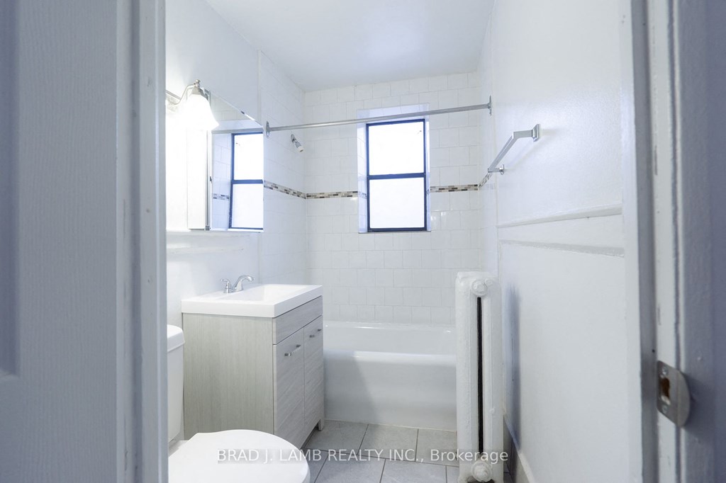 a white bathroom with a tub and a sink