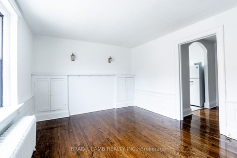 a living room with white walls and wood floors
