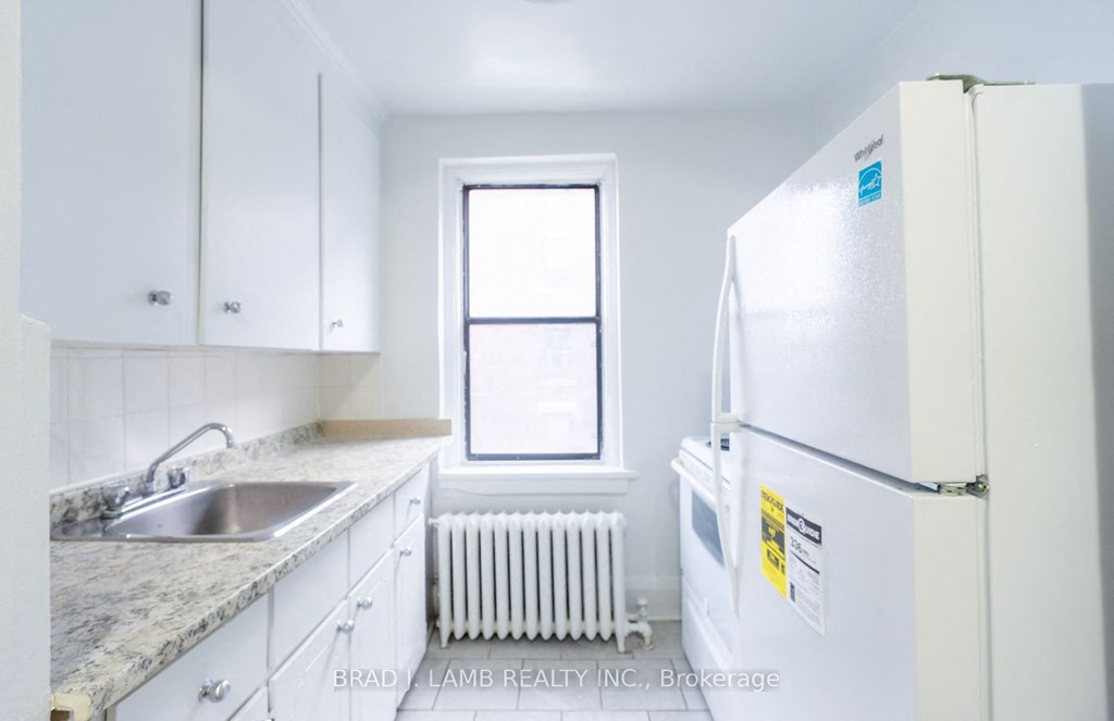 a kitchen with white cabinets and a white refrigerator