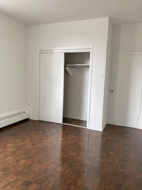 an empty room with a wooden floor and an open door