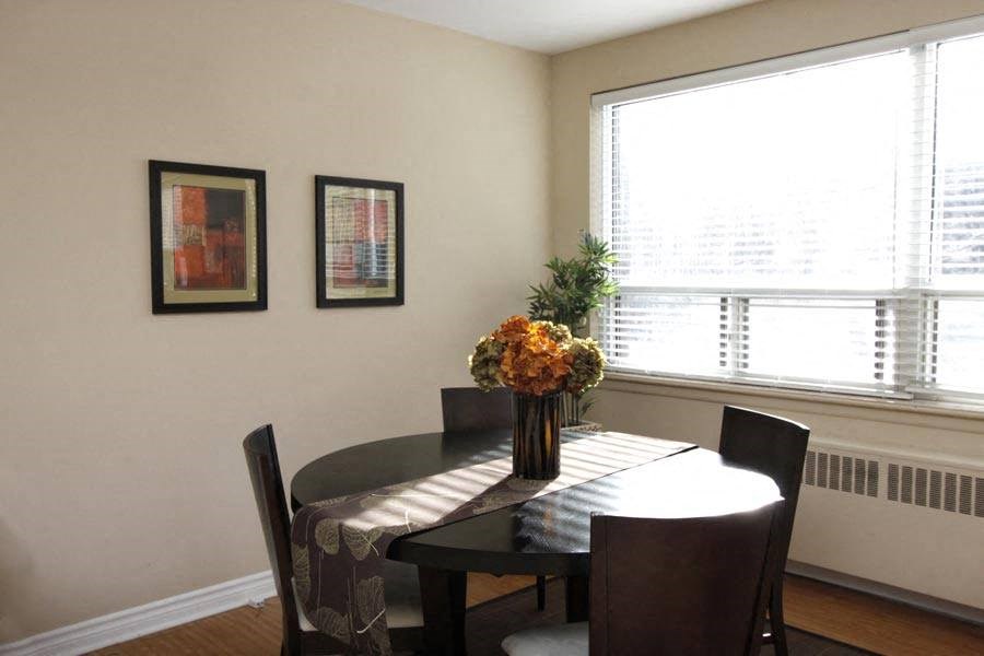 a dining room table with a vase of flowers on it