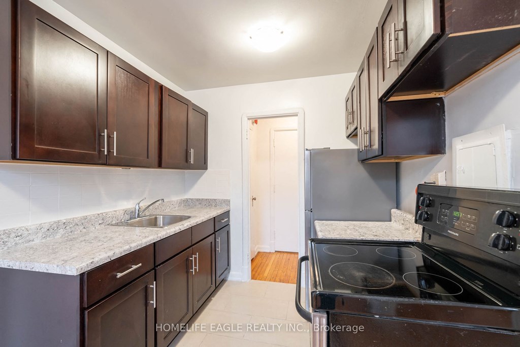 a kitchen with dark wood cabinets and black appliances