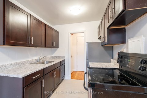a kitchen with dark wood cabinets and black appliances
