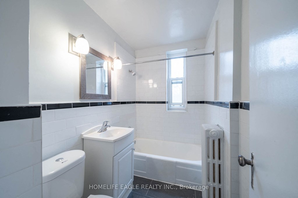 a white bathroom with a tub and a sink and a toilet