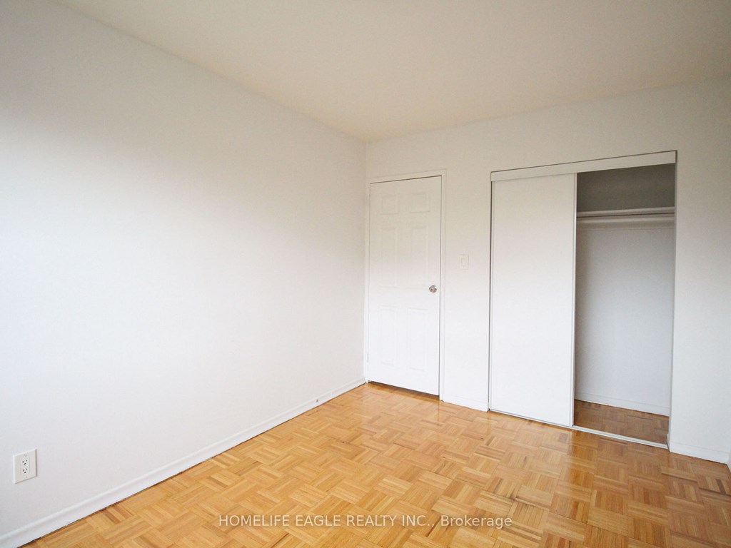 an empty room with white walls and wooden floors and a closet