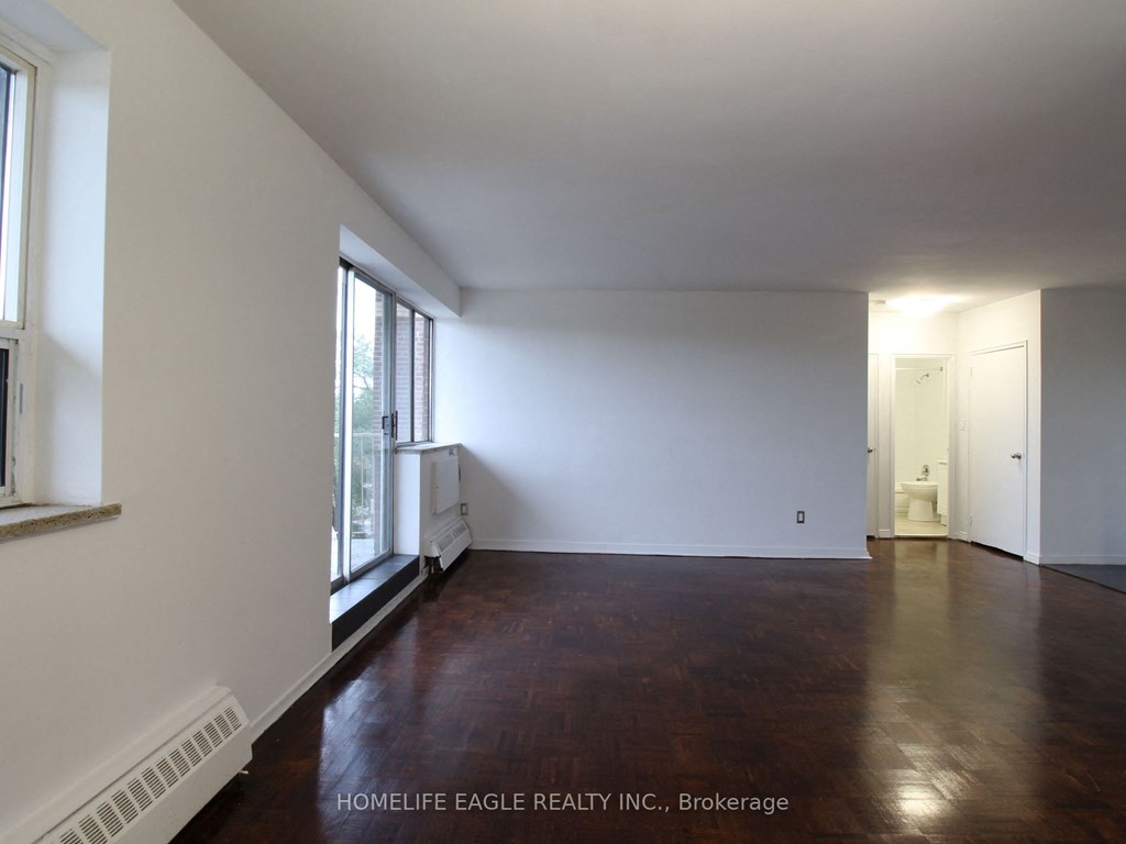 an empty living room with wood floors and white walls