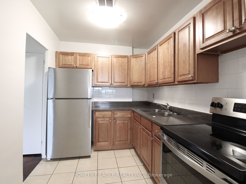 a kitchen with wooden cabinets and stainless steel appliances