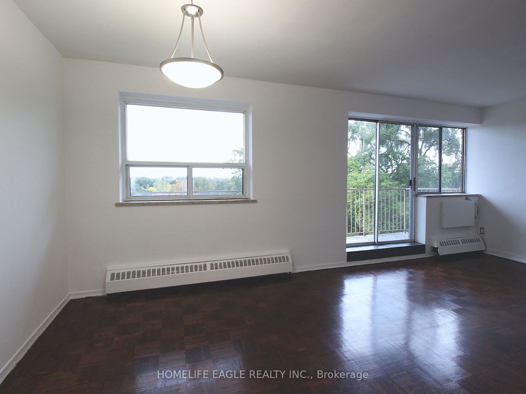 an empty living room with wood floors and a window