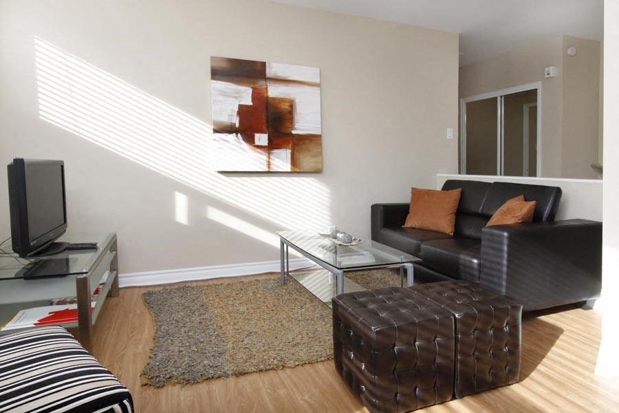 a living room with a black leather couch and a television