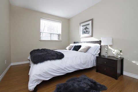 a bedroom with a white bed and a window