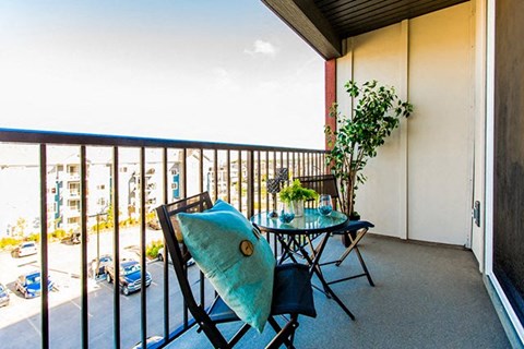 a balcony with a table and chairs and a view of the ocean