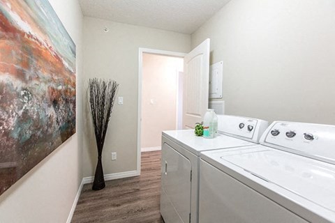 a laundry room with a washer and dryer and a door to a bathroom