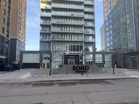 The image shows a modern building with the name "SOHO" on the entrance.