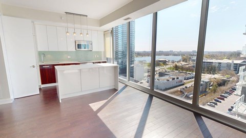 A large open space with a kitchen area and a view of the city.