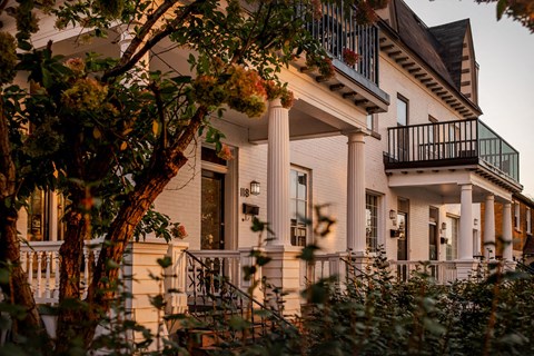 A white house with a balcony and columns.