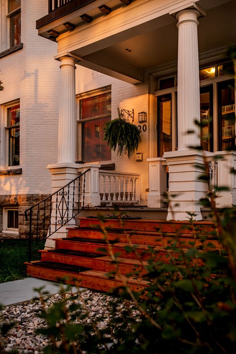 A white house with a red staircase leading to the front door.