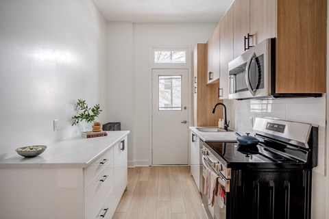 A kitchen with white cabinets and a black stove top.