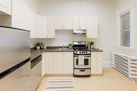 A modern kitchen with white cabinets and appliances.