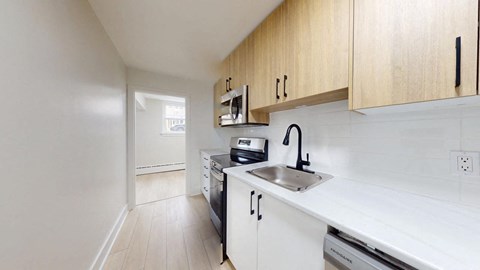 A kitchen with white appliances and wooden cabinets.