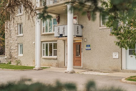 A building with a balcony and a brown door.