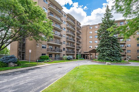 A large apartment complex with a grassy area in front.