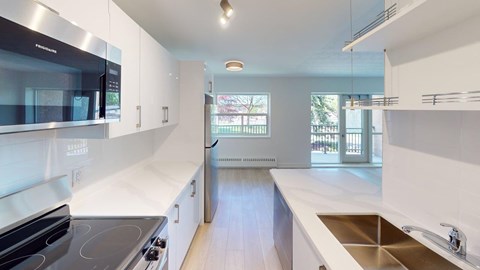 A modern kitchen with white cabinets and stainless steel appliances.