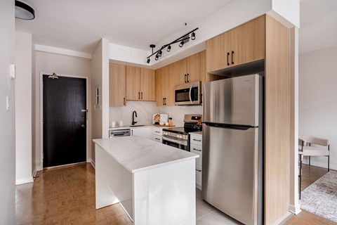 A modern kitchen with wooden cabinets and stainless steel appliances.