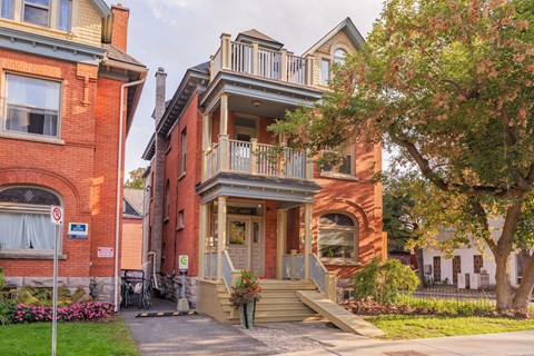 A red brick building with a balcony and a door.