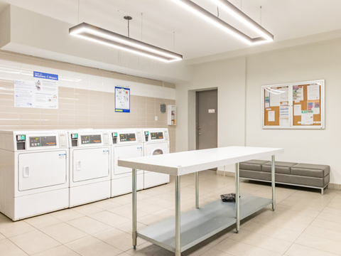 A laundromat with a white table in the middle of the room.