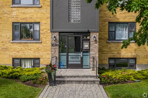 The front of a brick building with a glass door and window.