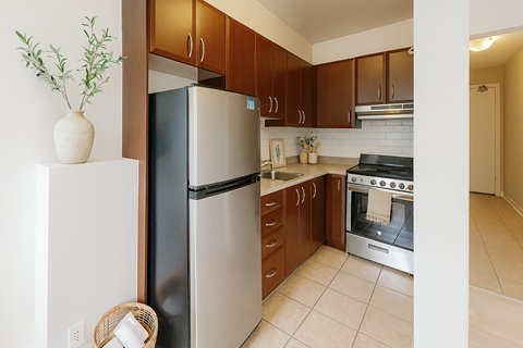 A kitchen with a refrigerator, oven, and cabinets.