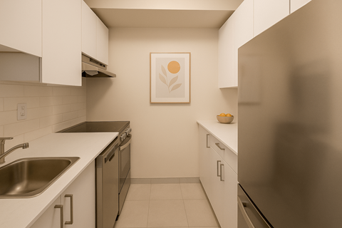 A kitchen with a refrigerator, sink, and cabinets.