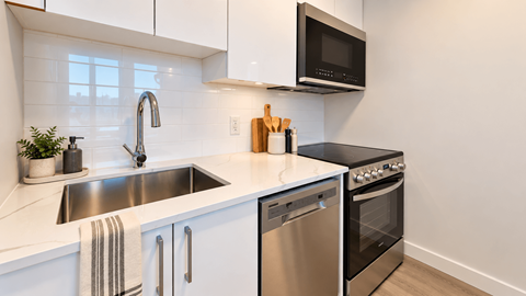 A modern kitchen with a stainless steel dishwasher and oven.