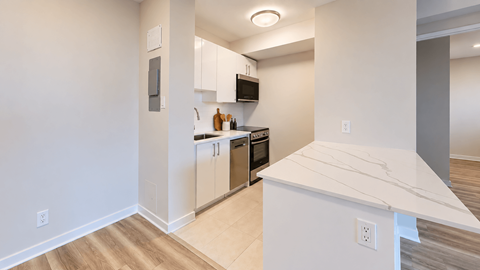 A kitchen with white cabinets and a white countertop.