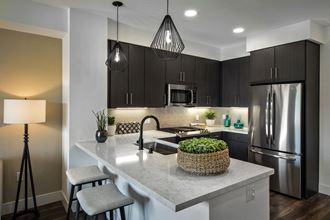 a kitchen with a large island and stainless steel refrigerator