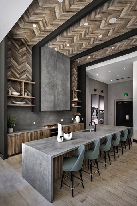 A modern kitchen with a long island and chairs at Purl Apartments, San Diego