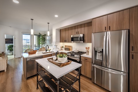 A modern kitchen with stainless steel appliances and wooden cabinets.