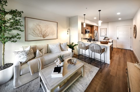 A modern living room with a white sofa and a glass coffee table.