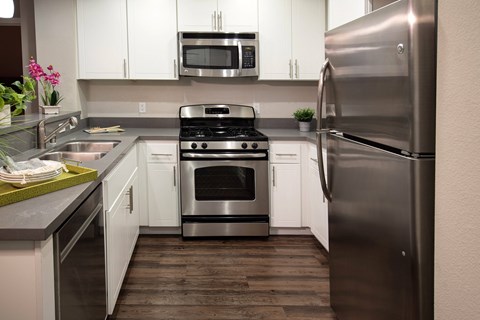 a kitchen with stainless steel appliances and white cabinets