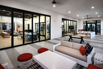 A modern living room with a white sofa and a black and white checkered table.
