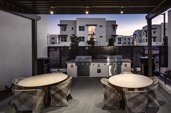 A patio with a table and chairs is set up on a balcony.