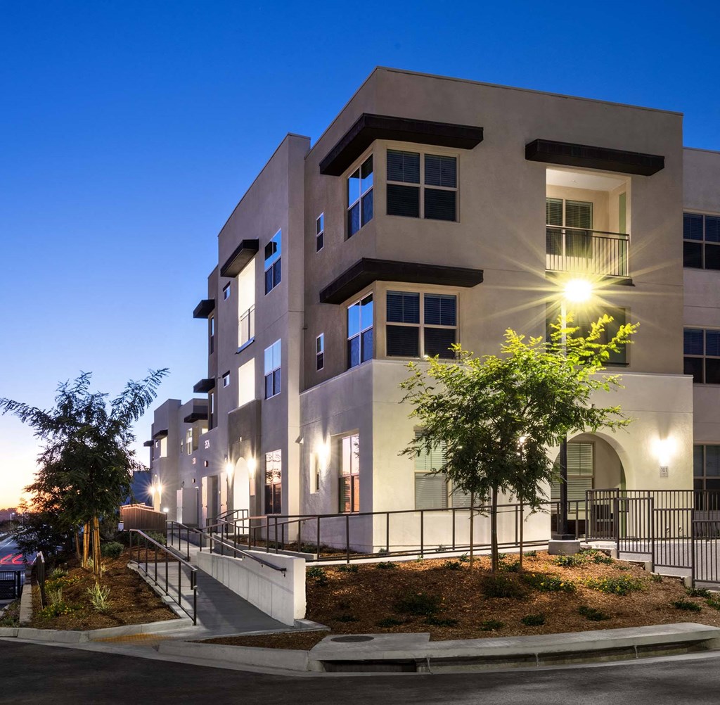 an image of a building at night with lights on it an image of a building at night with lights on it at Luma at El Corazon Apartments, Oceanside, CA 92056