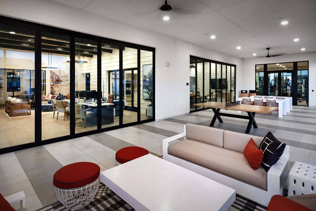 a living room with a white couch and tables at Luma at El Corazon Apartments, Oceanside, California
