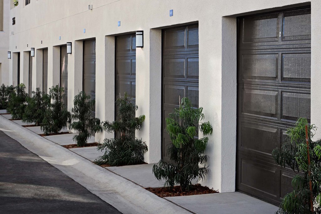 a row of garage doors and a sidewalk at Luma at El Corazon Apartments, Oceanside, California