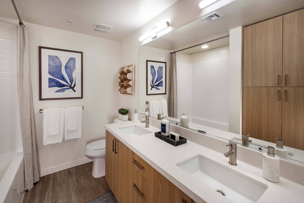a bathroom with two sinks and a toilet at Luma at El Corazon Apartments, Oceanside, CA